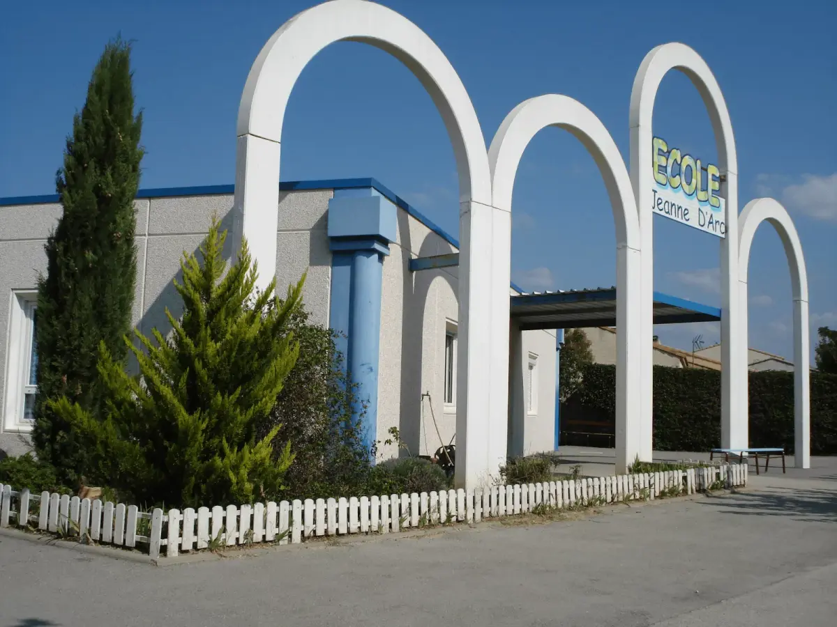 La façade de l'école et ses arches blanches, côté entrée